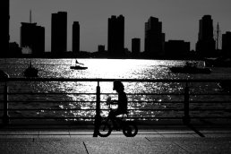 Black and white photography shadow child bike skyline New York