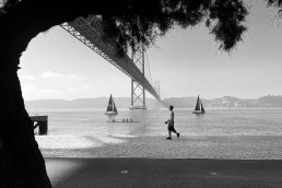 black and white photography man walking boats Bridge Lisboa