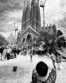 Black and white street photography fine art boy playing with bubbles Sagrada Familia Barcelona